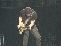 U2  Performing on a proscenium in black high top chucks.