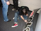 All American Rejects  Nick Wheeler signs a radio station board while others look on.