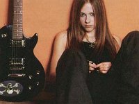 Avri Lavigne  Avril sits alone, next to her guitar sporting her black low cut chucks.
