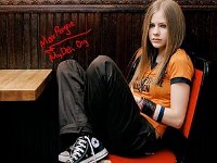 Avril Lavigne  Avril seated in a chair wearing black high top chucks.