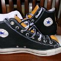 Brad Deniston Collection of Chucks  Inside patch views of black and gold 2-tone high tops with black and white reversible shoelaces.