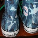 Brad Deniston Collection of Chucks  Rear view of blue camouflage high tops with green shoelaces.