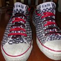 Brad Deniston Collection of Chucks  Front view of black and white checkered low cut chucks with red and black reversible laces.
