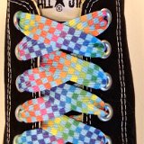 Rainbow Checkered Print Shoelaces On Chucks  Rainbow checkered print shoelace on a black low top chuck.