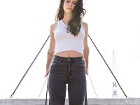 Meg Myers  Hanging onto a fire escape and wearing black low cut chucks.