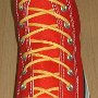 Narrow Round Shoelaces  Red high top with narrow yellow laces.
