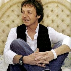 Paul McCartney  Sir Paul sitting crisscross with black high top chucks on.