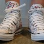 Rock and Roll High Top Chucks  Wearing white punk print high tops, front view 1.