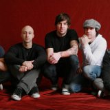 Simple Plan  Chuck Comeau, David Desrosiers, and Jeff Stinco seated wearing chucks.