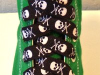 Skull Print Shoelaces On Chucks  Black and white skull print shoelace on a kelly green high top.