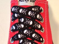 Skull Print Shoelaces On Chucks  Black and white skull print shoelace on a red low cut.