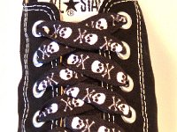 Skull Print Shoelaces On Chucks  Black and white skull print shoelace on a black low cut.