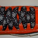Star Print Shoelaces on Chucks  Orange high top chuck with black and silver star print shoelaces.