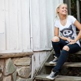 Tonight Alive  Jenna seated on some wooden stairs wearing black high top chucks.