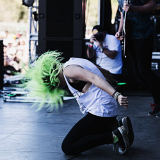 Tonight Alive  Jenna kneeling down on stage.