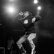 Vince Staples  A cool black and white shot of Vince Staples while he performs in black high top chucks.