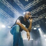 Vince Staples  Vince wears black high top chucks while performing.