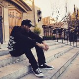 YG  YG dressed in all black including black high top chucks on the steps of his home.